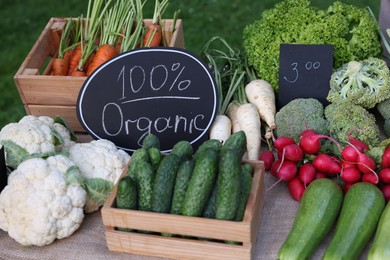 Photo of Many different vegetables and 100% Organic sign on stall at farmer's market