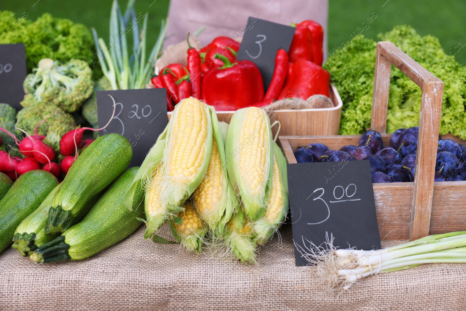 Photo of Many different vegetables and plums on stall at farmer's market, closeup