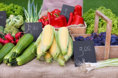 Photo of Many different vegetables and plums on stall at farmer's market, closeup