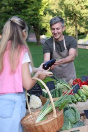 Photo of Woman choosing fresh vegetables from stall at farmer's market