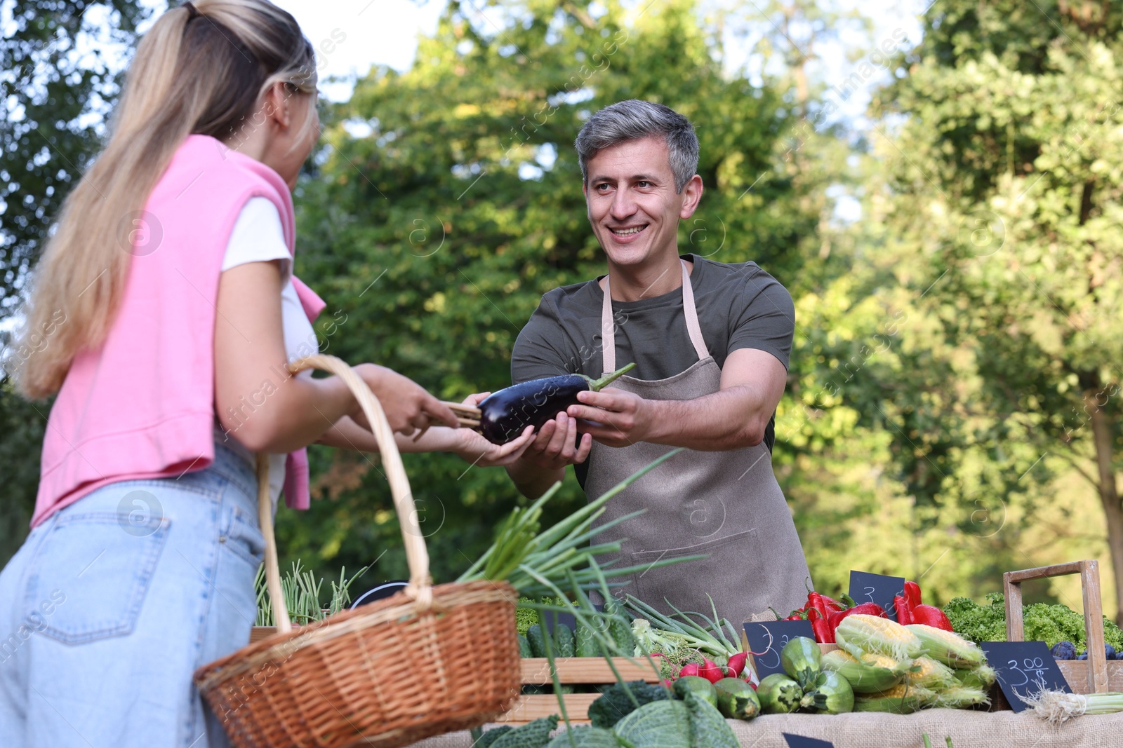Photo of Woman choosing fresh vegetables from stall at farmer's market