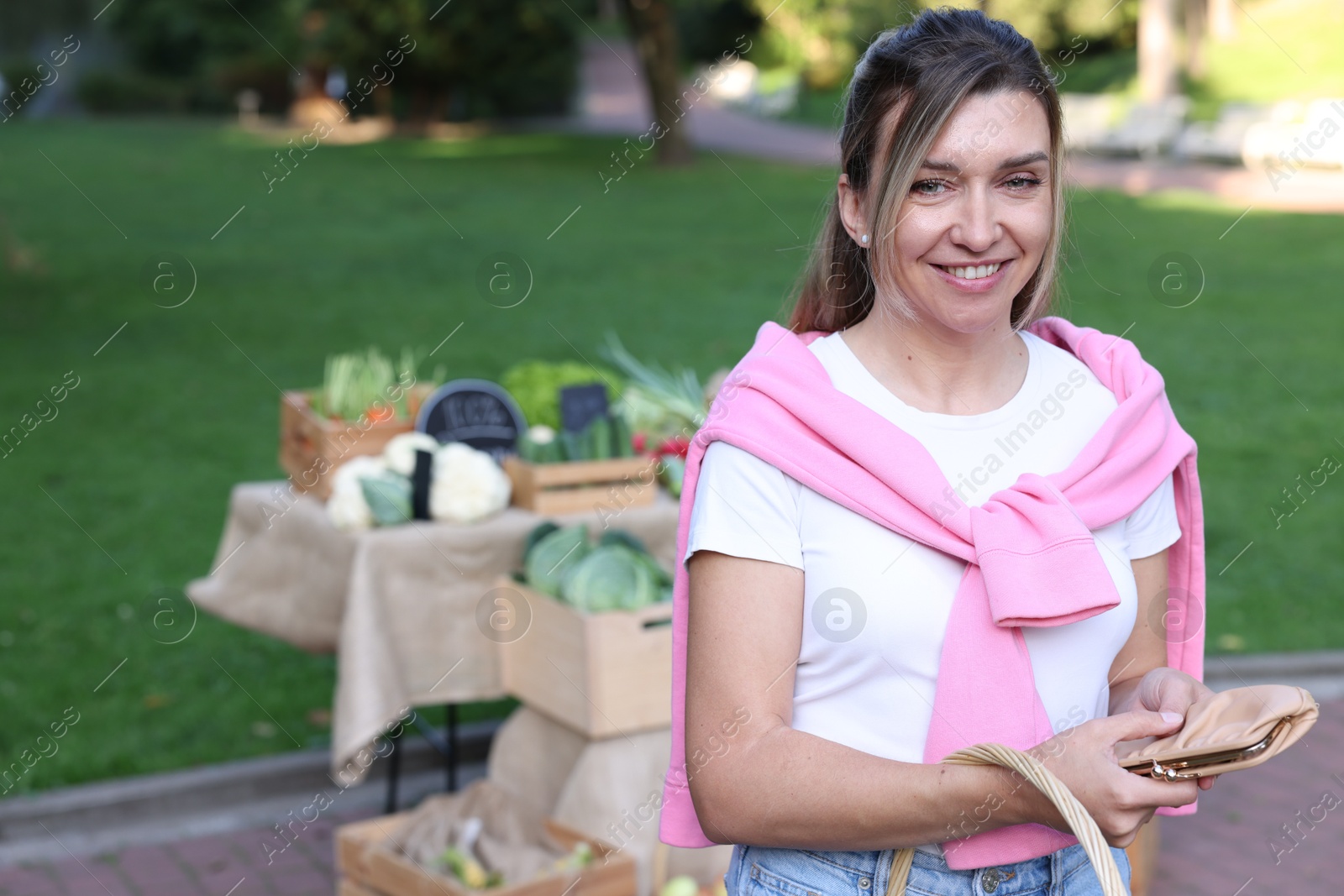 Photo of Woman holding wallet near stall at farmer's market