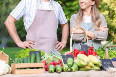 Photo of Farmers near stall with different fresh vegetables at market, closeup