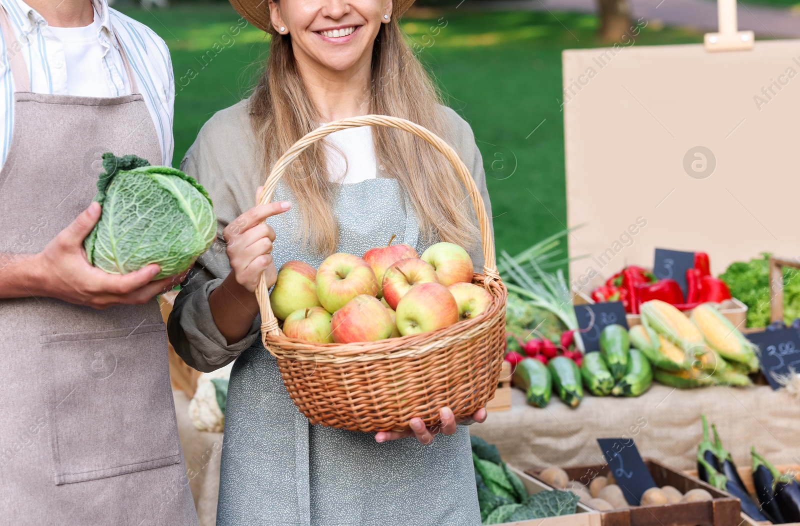 Photo of Farmers with products near stall with different fresh vegetables at market, closeup