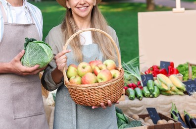 Photo of Farmers with products near stall with different fresh vegetables at market, closeup