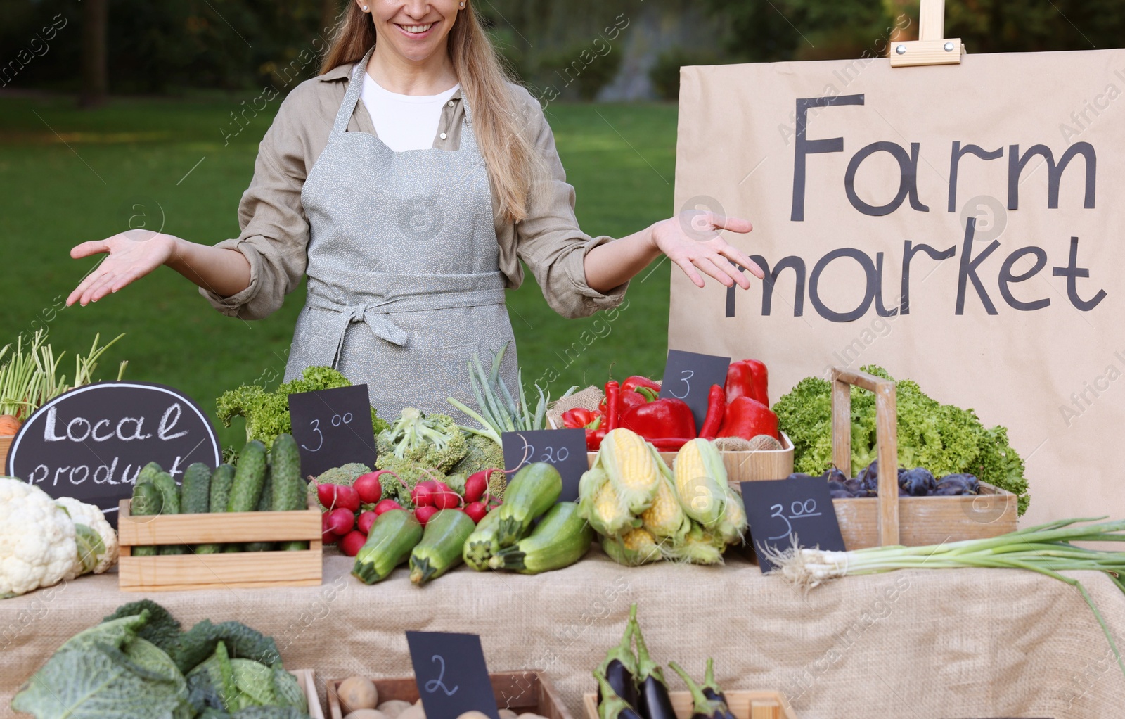 Photo of Farmer near stall with different fresh vegetables at market, closeup