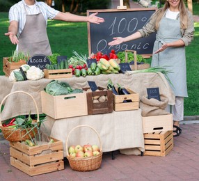 Photo of Farmers near stall with different fresh vegetables at market, closeup