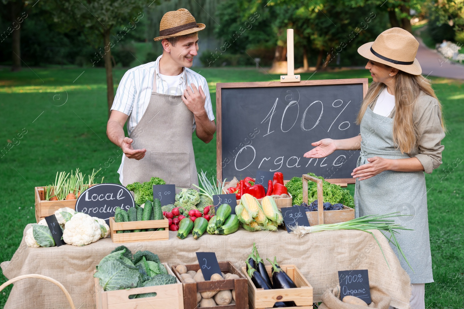 Photo of Farmers near stall with different fresh vegetables at market