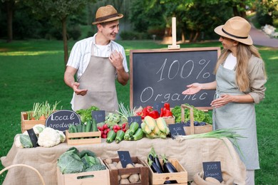 Photo of Farmers near stall with different fresh vegetables at market