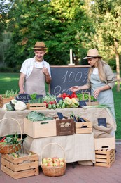 Photo of Farmers near stall with different fresh vegetables at market