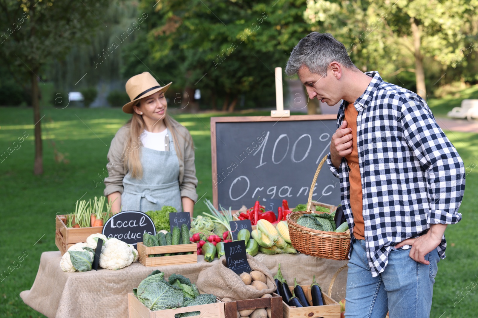 Photo of Man choosing fresh vegetables from stall at farmer's market