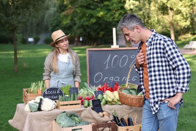 Photo of Man choosing fresh vegetables from stall at farmer's market