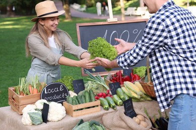 Photo of Man choosing fresh vegetables from stall at farmer's market, closeup