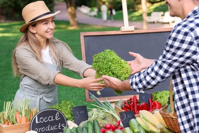 Photo of Man choosing fresh vegetables from stall at farmer's market, closeup
