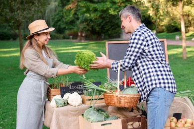 Photo of Man choosing fresh vegetables from stall at farmer's market