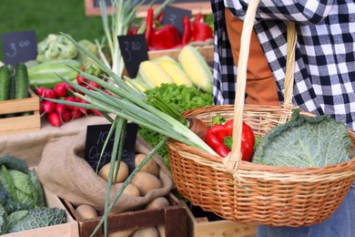 Photo of Man choosing fresh vegetables from stall at farmer's market, closeup