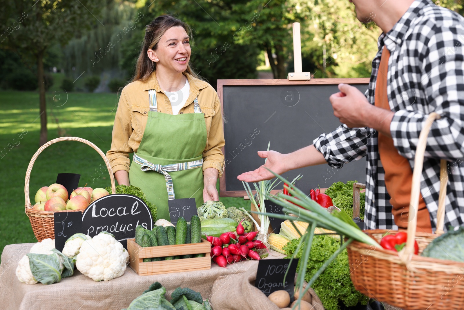 Photo of Man choosing fresh vegetables from stall at farmer's market, closeup