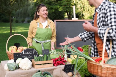 Photo of Man choosing fresh vegetables from stall at farmer's market, closeup