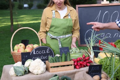 Photo of Man choosing fresh vegetables from stall at farmer's market, closeup