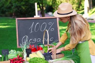 Photo of Farmer near stall with plums and different fresh vegetables at market