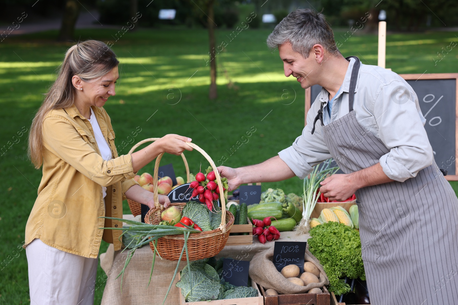 Photo of Woman choosing fresh vegetables from stall at farmer's market