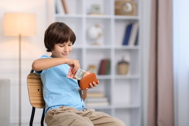 Photo of Boy putting his pocket money into wallet at home. Space for text