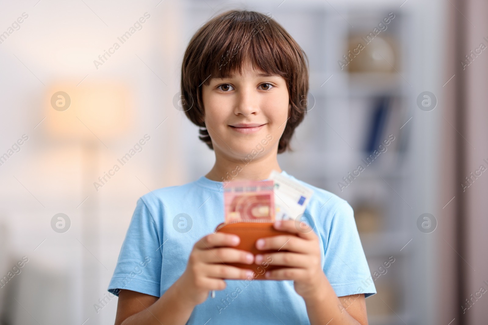 Photo of Boy with his pocket money in wallet at home