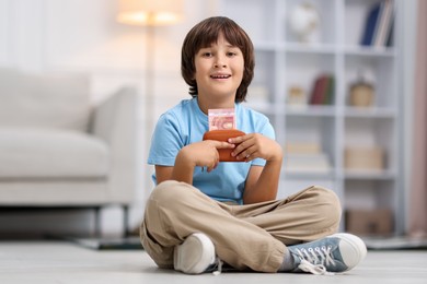 Photo of Boy with pocket money on floor at home