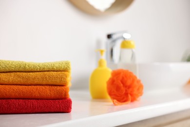 Photo of Stack of fresh terry towels on counter near sink