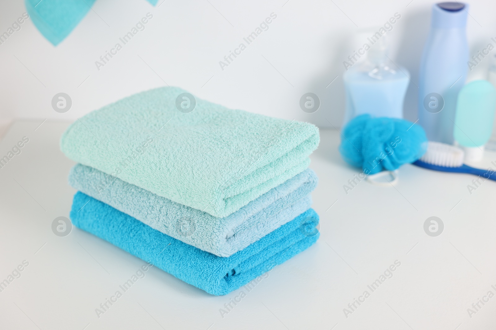Stack of fresh terry towels on white table in bathroom Photo of Stack of fresh terry towels on white table in bathroom