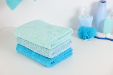 Photo of Stack of fresh terry towels on white table in bathroom