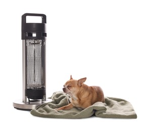 Photo of Cute little dog on blanket near electric heater against white background