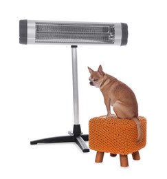 Photo of Cute little dog on pouf near electric heater against white background