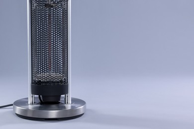 Photo of Modern electric heater on light grey background, closeup. Space for text