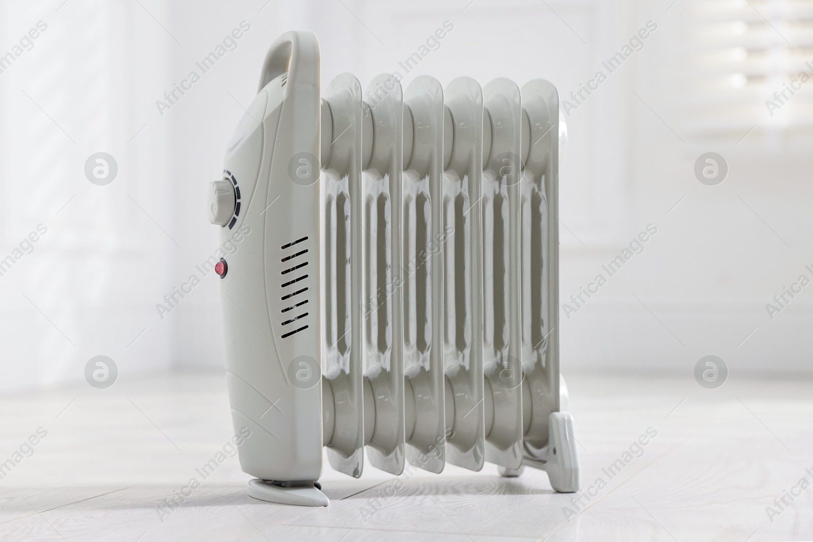 Photo of Modern electric heater on floor at home