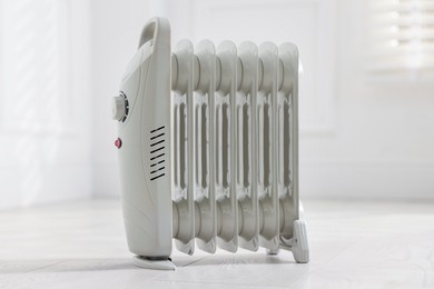 Photo of Modern electric heater on floor at home