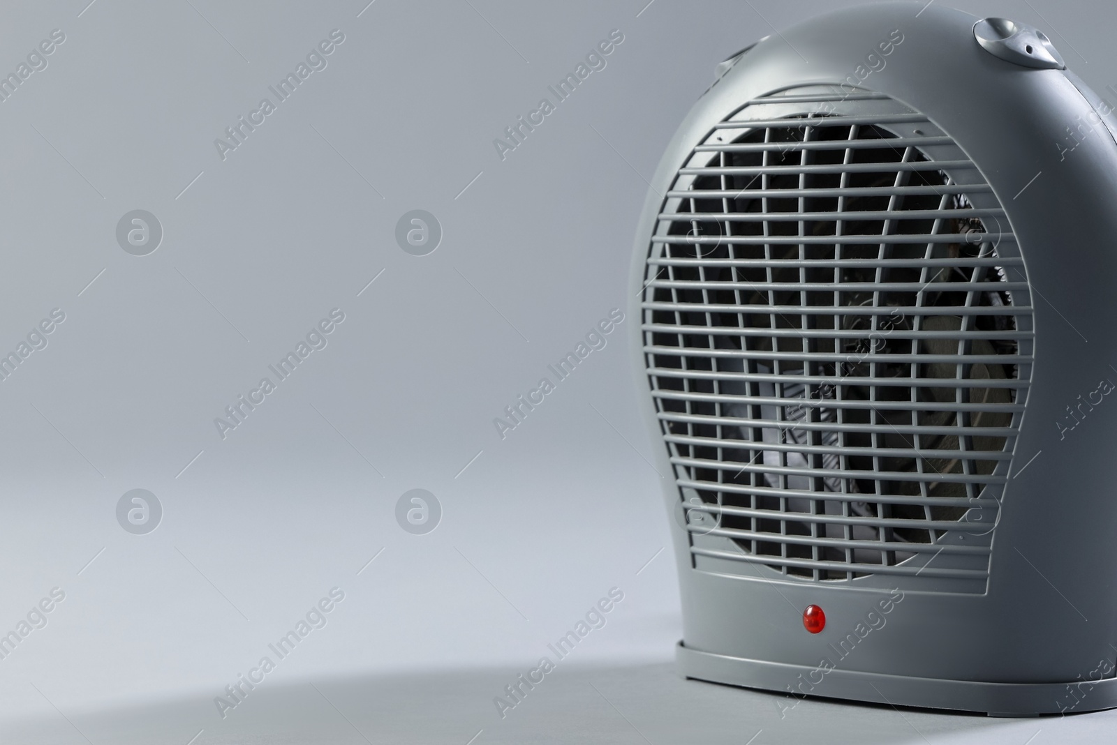 Photo of Modern electric fan heater on light grey background, closeup. Spae for text