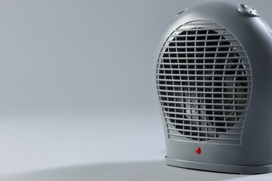 Photo of Modern electric fan heater on light grey background, closeup. Spae for text