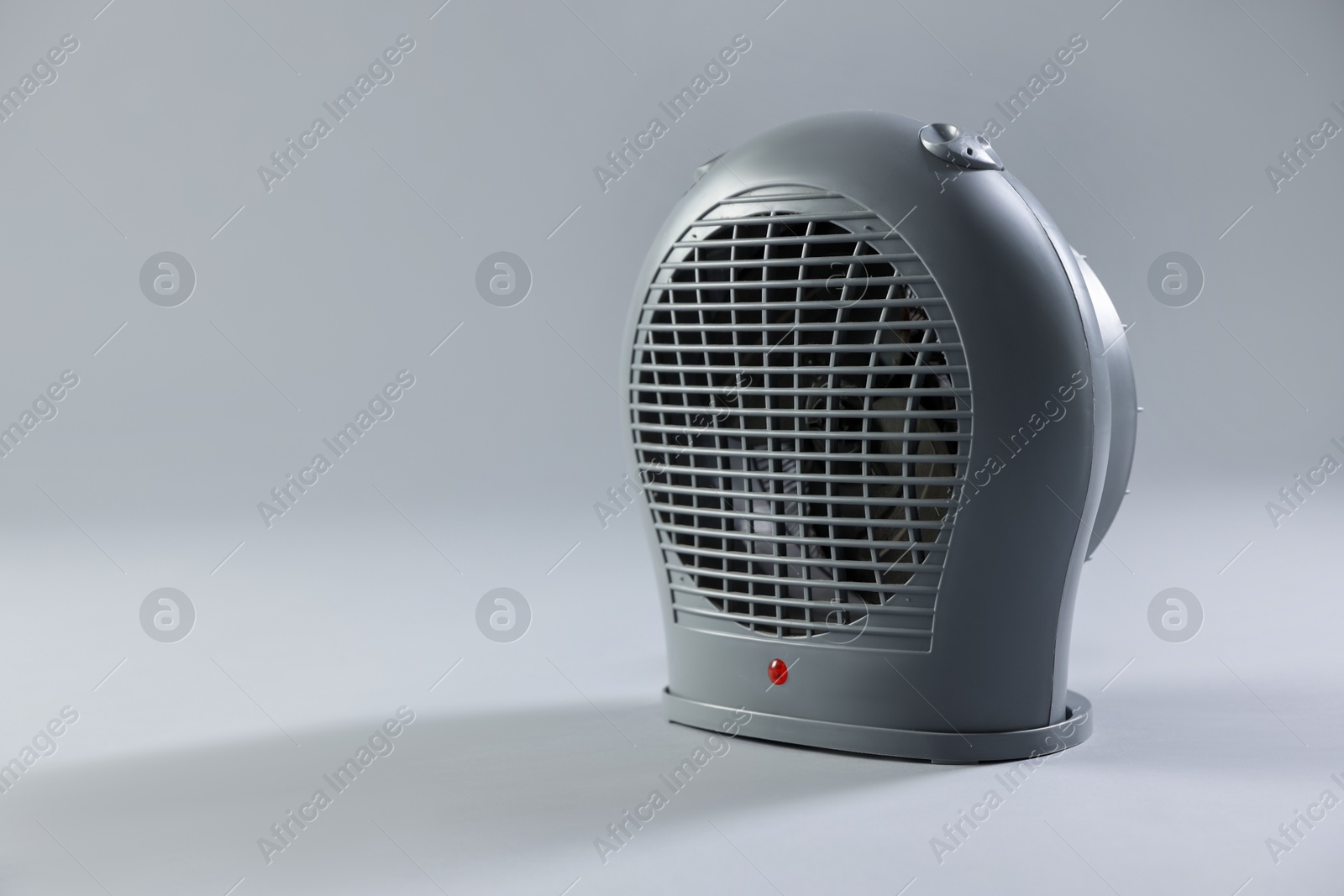 Photo of Modern electric fan heater on light grey background, space for text