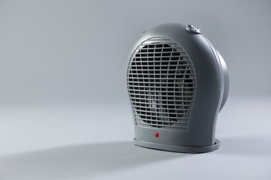 Photo of Modern electric fan heater on light grey background, space for text