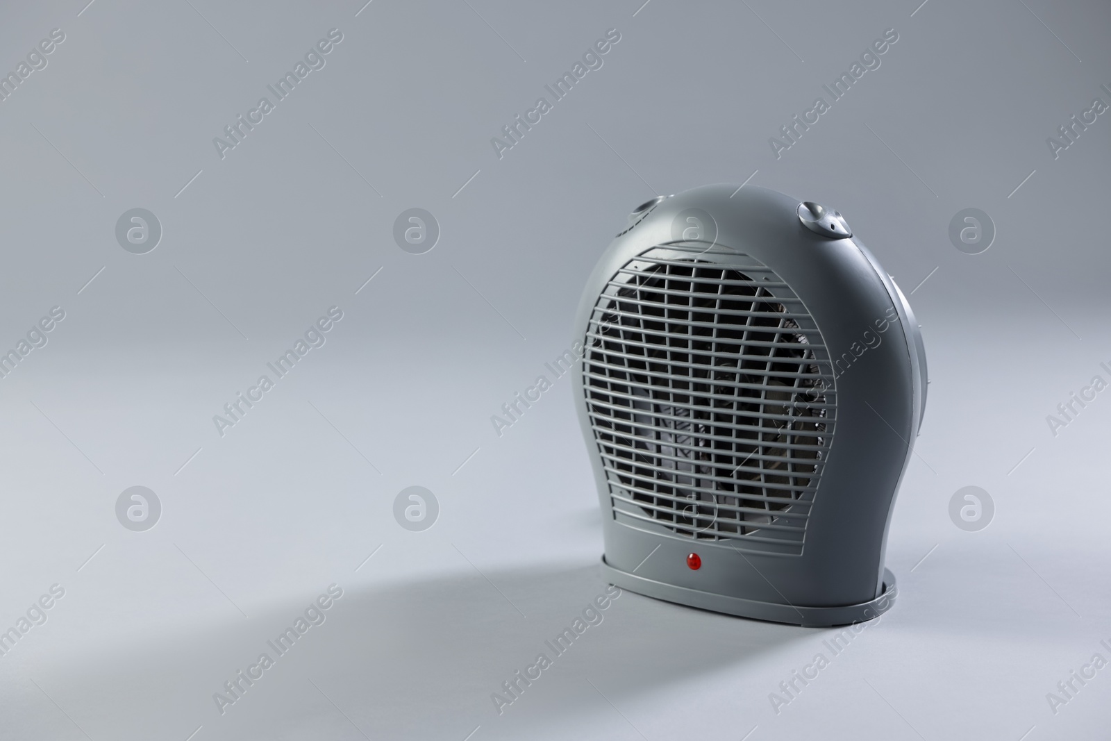 Photo of Modern electric fan heater on light grey background, space for text