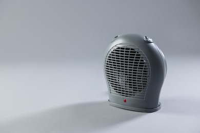 Photo of Modern electric fan heater on light grey background, space for text