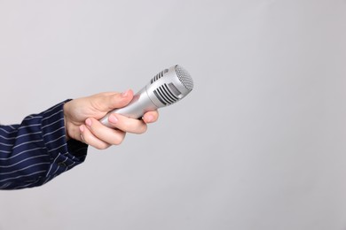 Photo of Journalist with microphone on light background, closeup. Space for text