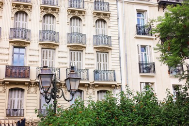 Photo of Beautiful building with windows and trees in city, low angle view