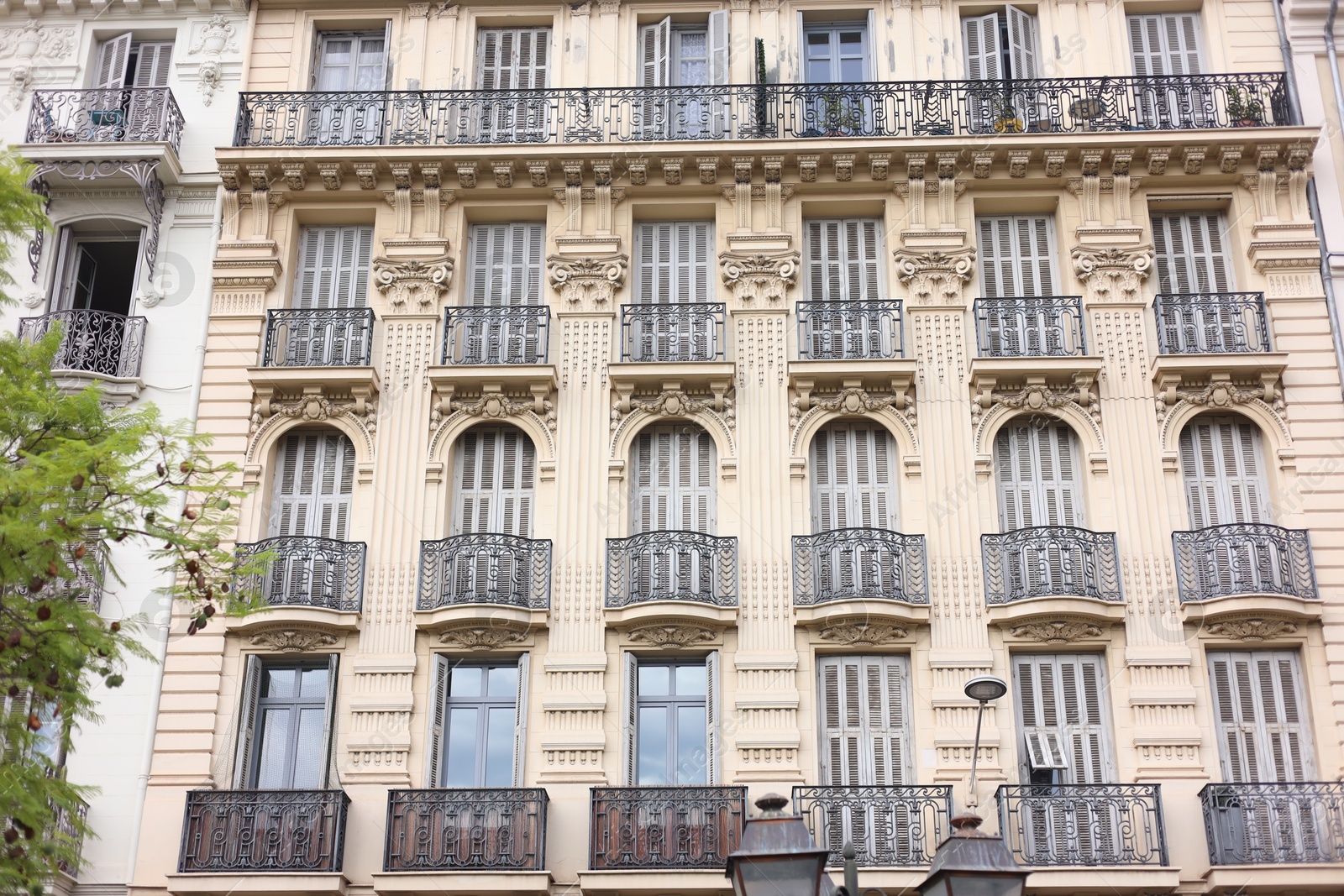 Photo of Beautiful building with windows and balconies in city, low angle view
