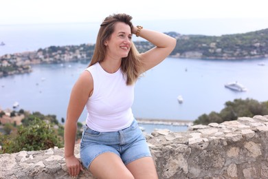 Photo of Beautiful woman sitting on bridge in city