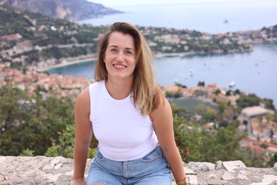 Photo of Beautiful woman sitting on bridge in city