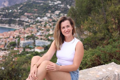 Photo of Beautiful woman sitting on bridge in city