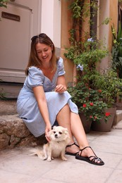 Photo of Beautiful woman with cute dog on city street
