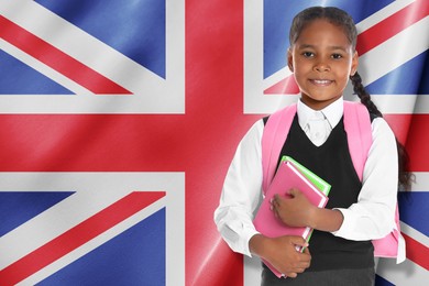 Image of Little girl with backpack and notebooks against flag of United Kingdom. Language school